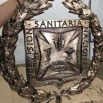 Escudo de bronce opt 150x150 - Restauraciones